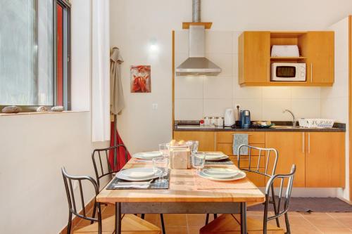a kitchen with a wooden table with chairs around it at Calheta Lofts I in Calheta
