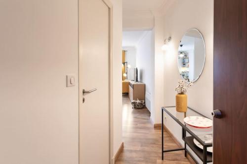 einen Flur mit einem Spiegel und einem Tisch mit einem Waschbecken in der Unterkunft #1 Studio Fontaine de la Ville-WIFI in Nizza