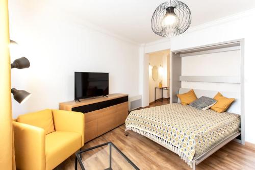 a bedroom with a bed and a couch and a television at #1 Studio Fontaine de la Ville-WIFI in Nice