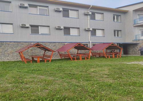 a row of wooden benches in front of a building at Мотель ОК in Shepetivka