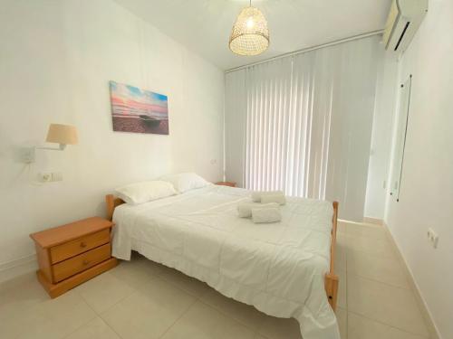 um quarto branco com uma cama com toalhas em Cozy apartment on the beach of Calpe em Calpe