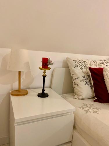 a white bed with a table with a lamp on it at Farmhouse Dzeni in Vlasic