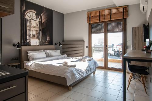 sypialnia z łóżkiem i biurkiem oraz kuchnią w obiekcie 4 Seasons Luxury Apartments w Aleksandropolis