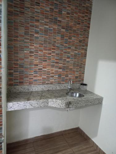 uma casa de banho com um lavatório e uma parede de tijolos em Chalés Ocaso em São Jorge