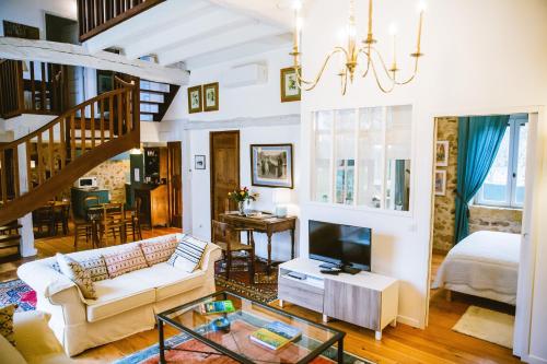 un salon avec un canapé et une télévision dans l'établissement la grange de pyraine, à Issac