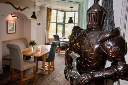 a statue in a living room with a table and chairs at Sir William Hotel in Grindleford Bridge