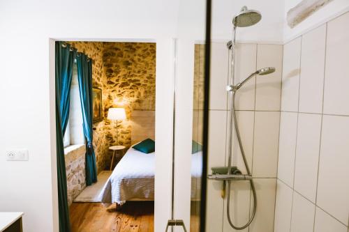 Cette chambre comprend un lit et une salle de bains pourvue d'une douche. dans l'établissement la grange de pyraine, à Issac