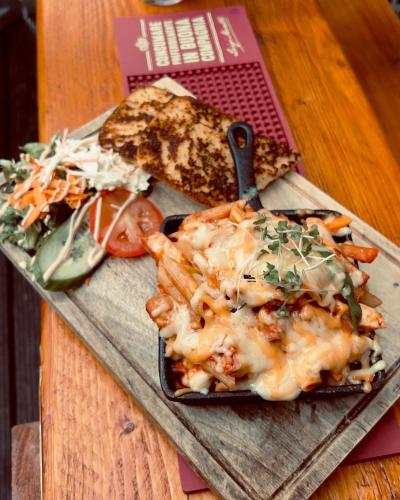a plate of food with pasta and vegetables on a cutting board at The Bailey Gastro Bar in Athlone