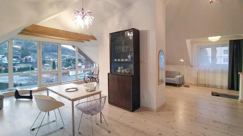 a living room with a table and chairs and a refrigerator at Apartament u Tomka Lux in Ustrzyki Dolne