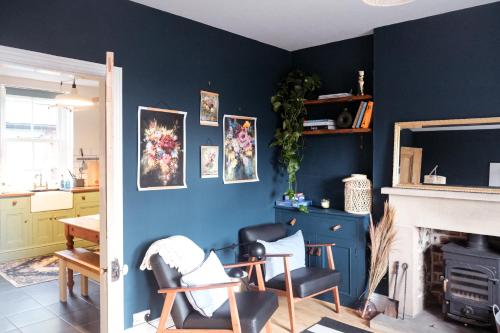 a living room with blue walls and a fireplace at Gorgeous 3 bed house in Matlock + Garden ‘lookout’ in Matlock