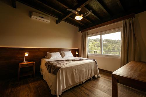 Un dormitorio con una cama grande y una ventana en Fazenda Verde - Praia do Rosa, en Praia do Rosa