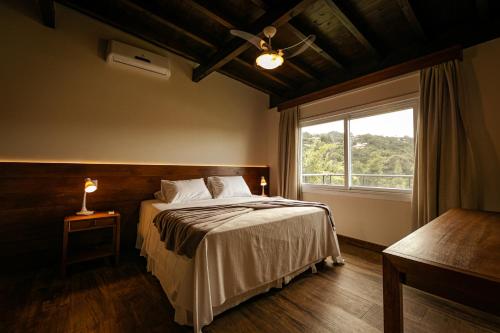 ein Schlafzimmer mit einem großen Bett und einem Fenster in der Unterkunft Fazenda Verde - Praia do Rosa in Praia do Rosa