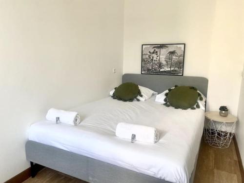 un lit blanc avec deux serviettes dessus dans l'établissement Calme à 10mn de l’aéroport d’Orly - Parking, à Orly