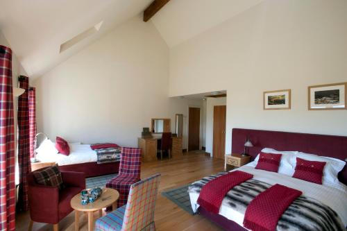 ein Schlafzimmer mit einem Bett und ein Wohnzimmer in der Unterkunft Langass Lodge in Carinish