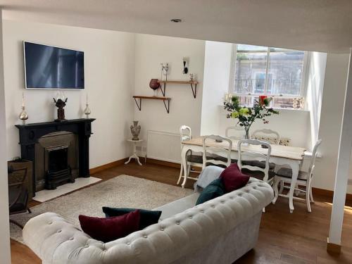 a living room with a couch and a table and a fireplace at Creathie Cathcart - Georgian Luxury at the beach in Ayr