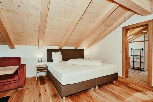 a bedroom with a bed in a room with wooden ceilings at Landhotel Berger in Ainring