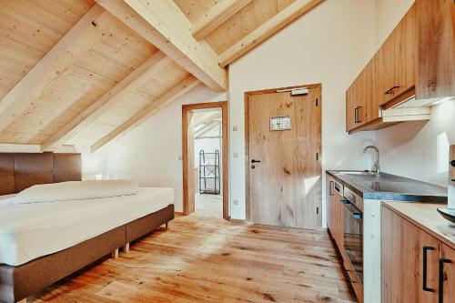 a bedroom with a bed and a kitchen at Landhotel Berger in Ainring