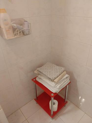 チステルナ・ディ・ラティーナにあるAppartamento del Colleのバスルームの赤いテーブルにタオルを積み重ねる