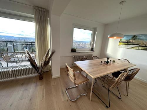 uma sala de jantar com mesa e cadeiras e uma grande janela em Ruhiges Penthouse mit Weitblick em Göttingen