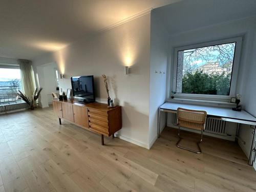 uma sala de estar com televisão e janela em Ruhiges Penthouse mit Weitblick em Göttingen