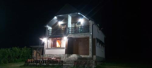 a building with a balcony at night at Holiday Home Drijenak in Kolašin