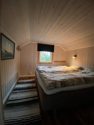 a bedroom with a bed in a room with a window at Rabben in Årjäng