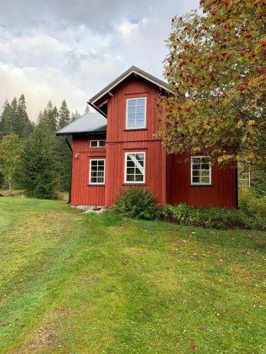 una casa rossa in mezzo a un campo di Rabben a Årjäng