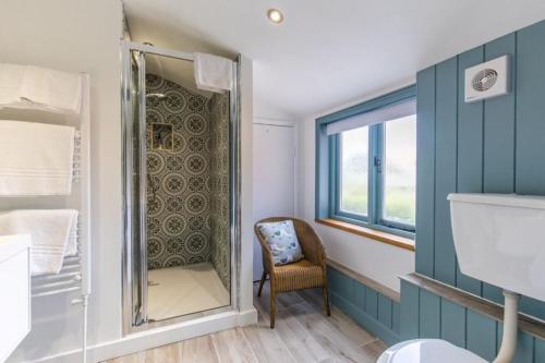 a bathroom with a shower and a chair at The Globe Inn in Wells next the Sea