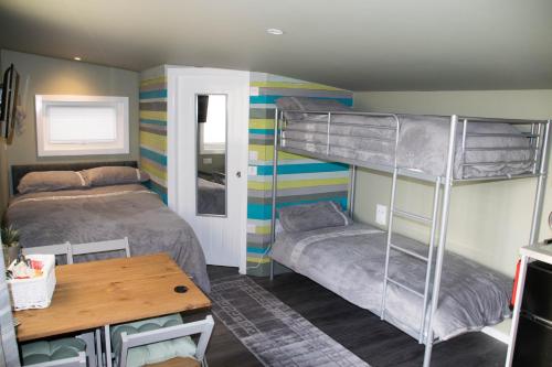 a bedroom with two bunk beds and a table at The Windy Roost in Occumster