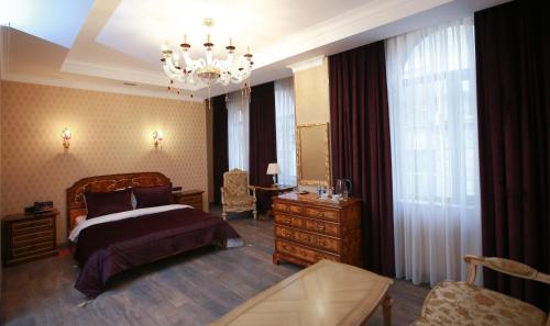 een slaapkamer met een bed en een kroonluchter bij West inn Hotel & Restaurant in Baku
