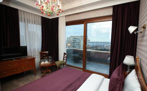 バクーにあるWest inn Hotel & Restaurantのベッドと大きな窓が備わるホテルルームです。