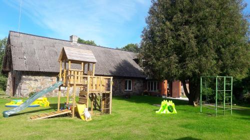 a playground in front of a house with a slide at Tuhala Jarve Talu in Tuhala