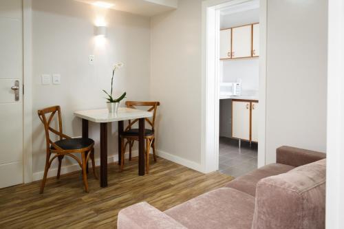 sala de estar con mesa y sofá en Apart Hotel Garibaldi, en Porto Alegre