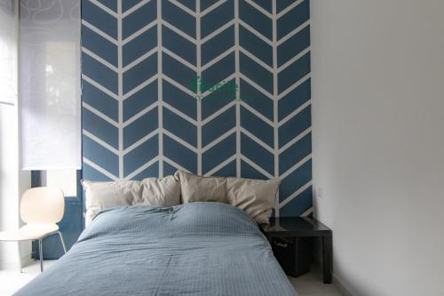 una camera con letto e parete blu e bianca di WELCOME HOME - CAMERA privata in Appartamento Condiviso a RHO a Rho