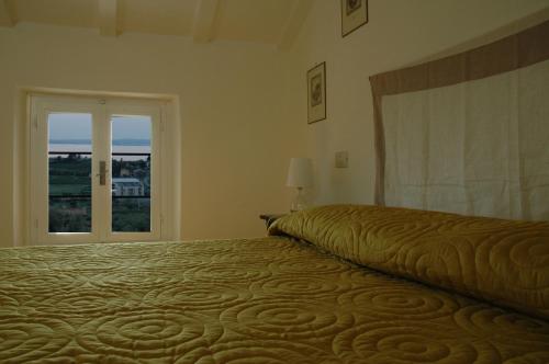 a bedroom with a large bed with a window at Agriturismo Tenuta la Pergola in Bardolino