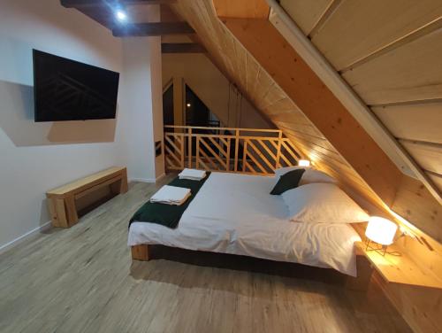 ein Schlafzimmer mit einem Bett im Loft mit einer Treppe in der Unterkunft Między Drzewami in Biecz