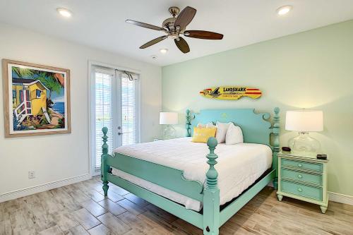 a bedroom with a blue bed and a ceiling fan at Margaritaville Home and Hot Tub, 3 Mi to Disney in Orlando