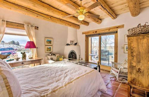 een slaapkamer met een groot bed en een open haard bij Casita Vacation Rental Near Taos with Patio! in El Prado