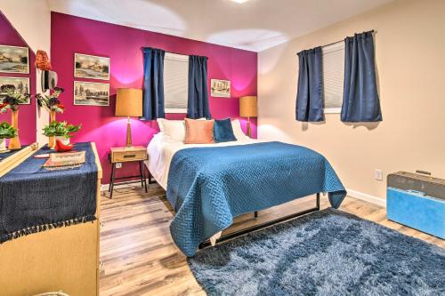 um quarto com paredes cor-de-rosa e uma cama com um cobertor azul em Stylish Vacation Rental - Walk to ISU! em Normal
