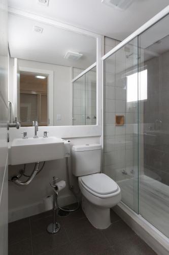 a bathroom with a toilet and a sink and a shower at Apart Hotel Garibaldi in Porto Alegre