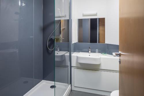 a bathroom with a sink and a glass shower at Warwick Conferences - Central Campus Venues in Coventry