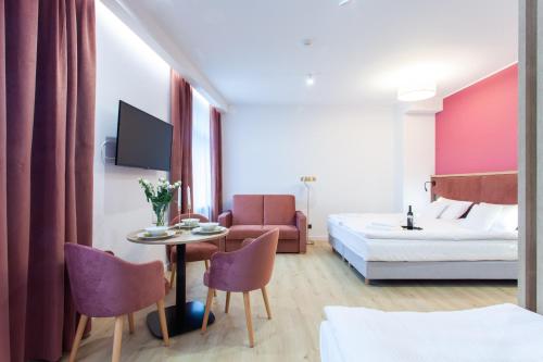 a hotel room with a bed and a table and chairs at SQUARE APARTMENTS GDYNIA in Gdynia