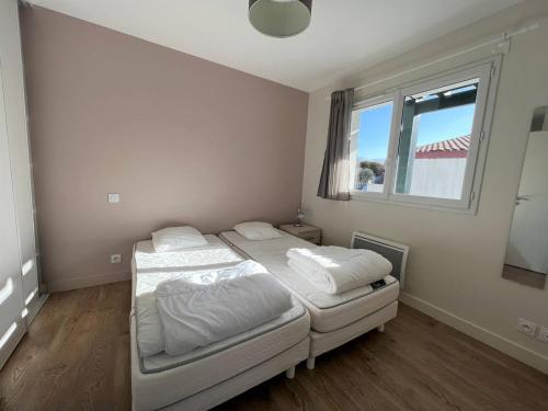 Un dormitorio con dos camas y una ventana. en Appartement T1 bis à Cambo, proche thermes et centre, RDC, terrasse, parking, internet, animal toléré - FR-1-495-12, en Cambo-les-Bains