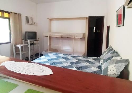 a small bedroom with a bed and a tv at Suites Americanas Em Jaconé in Jaconé