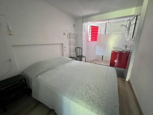 une chambre avec un lit blanc et une salle de bain dans l'établissement Rez-de-jardin rénové avec terrasse à Cambo-les-Bains, T1 Bis pour 2 personnes, équipé et lumineux - FR-1-495-93, à Cambo-les-Bains