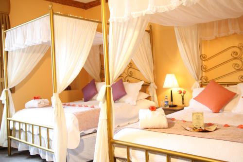 2 Betten in einem Zimmer mit weißen Vorhängen in der Unterkunft City Art Hotel Silberstein in Quito