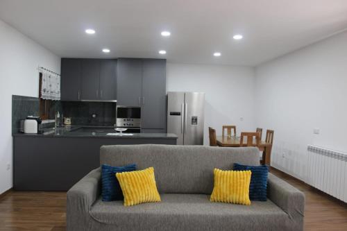 a living room with a couch and a kitchen at Casa do Iteiro in Caniçada