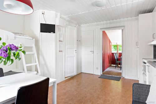 a kitchen with white cabinets and a table with purple flowers at First Camp Mölle-Höganäs in Mölle