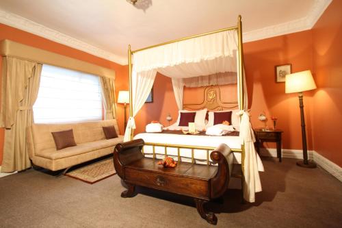 a bedroom with a canopy bed and a couch at City Art Hotel Silberstein in Quito