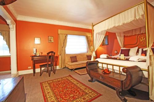 a bedroom with a canopy bed and a desk at City Art Hotel Silberstein in Quito
